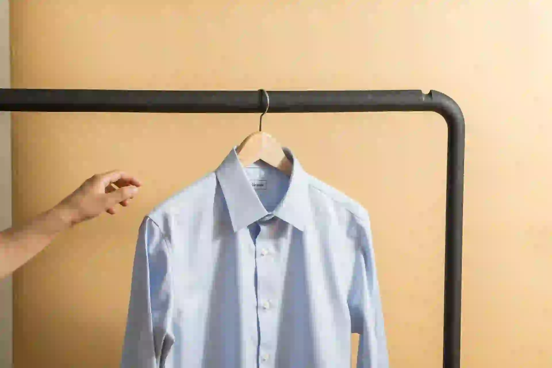 white button up shirt hanging on black metal bar